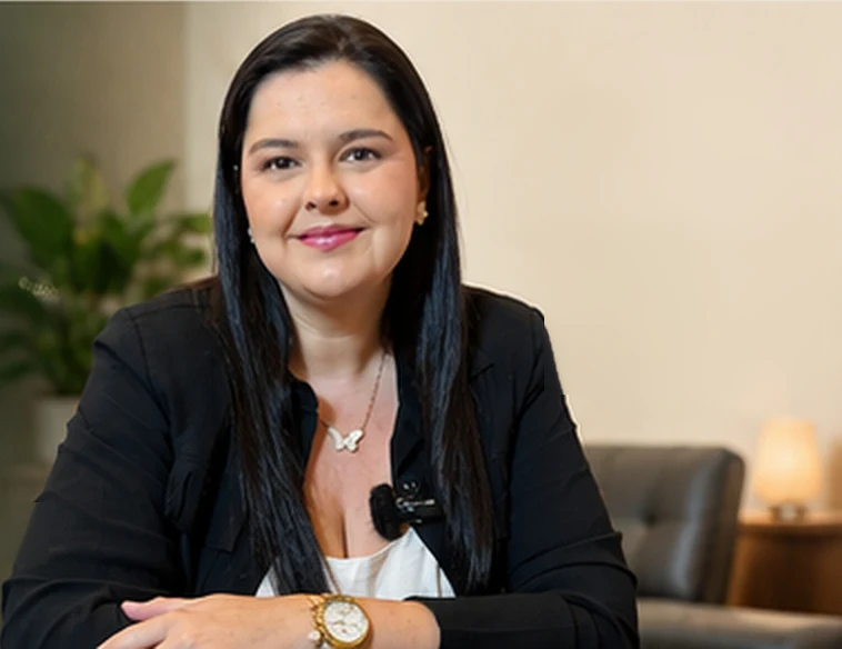 Raquel Mendes, nutricionista, de blazer preto, em seu consultório